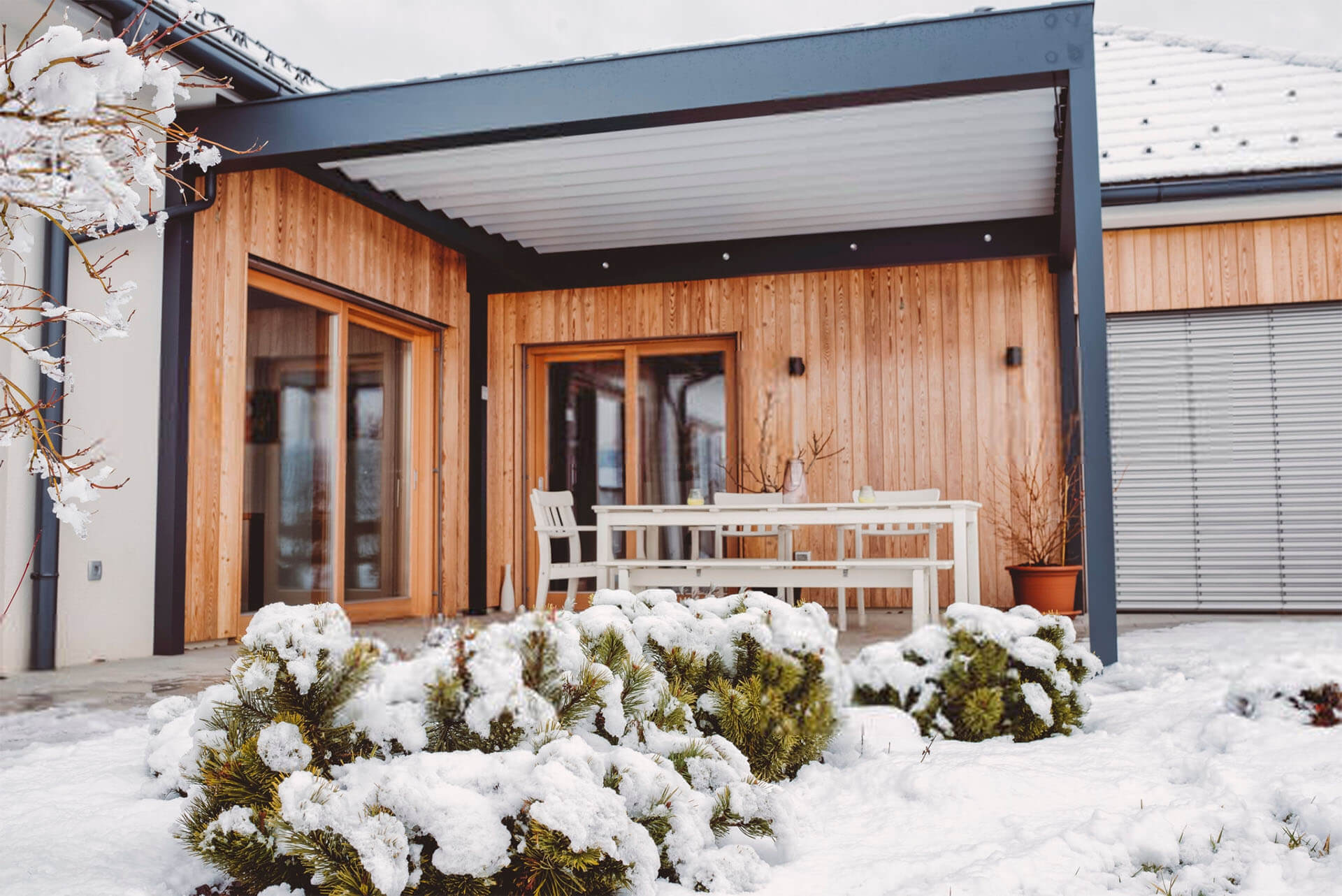 Warme Terrassenüberdachung aus schwarzem Aluminium im Schnee