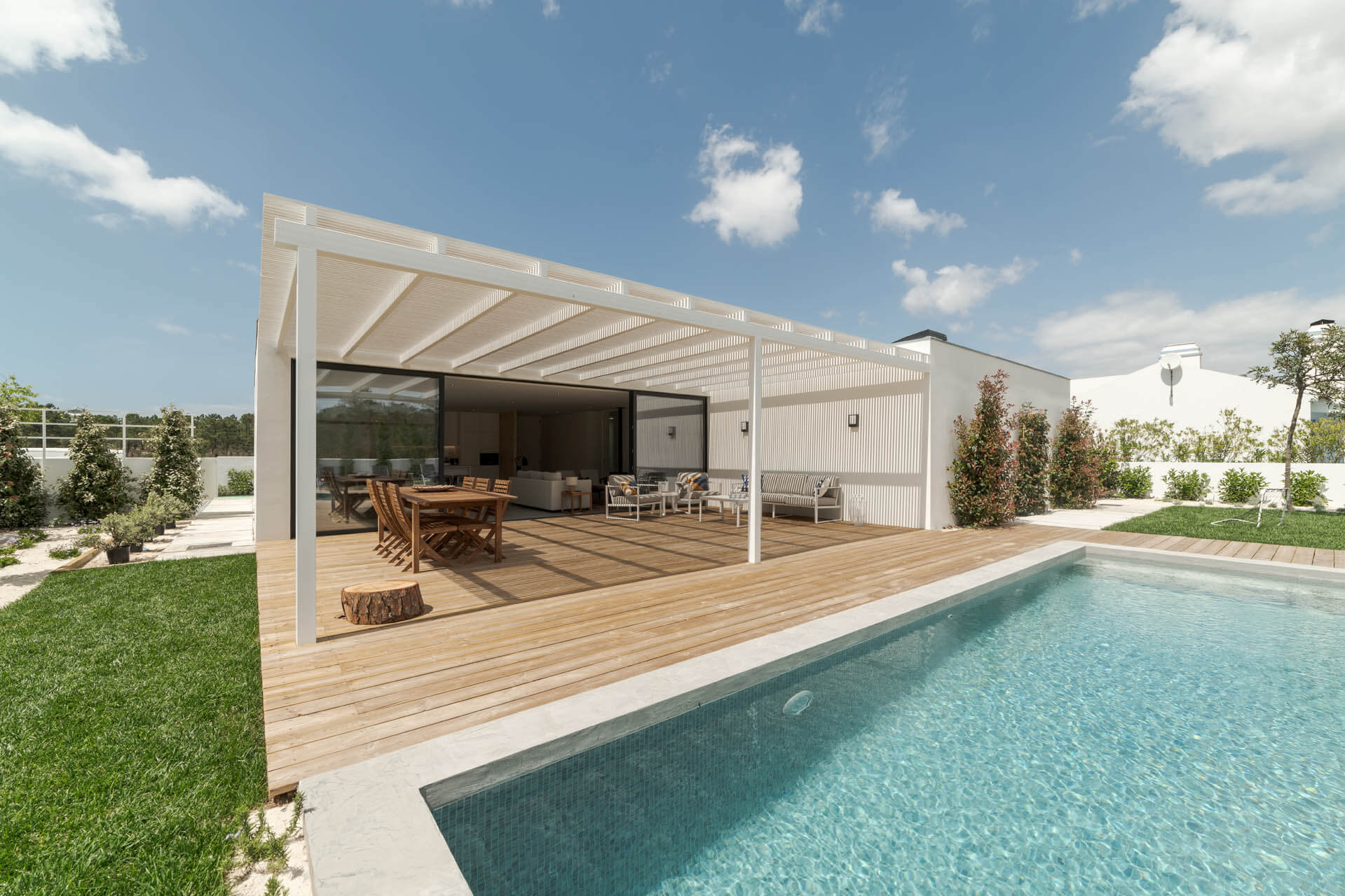 Modernes Haus mit Gartenschwimmbad, Holzterrasse und Pergola-Terrassenüberdachung